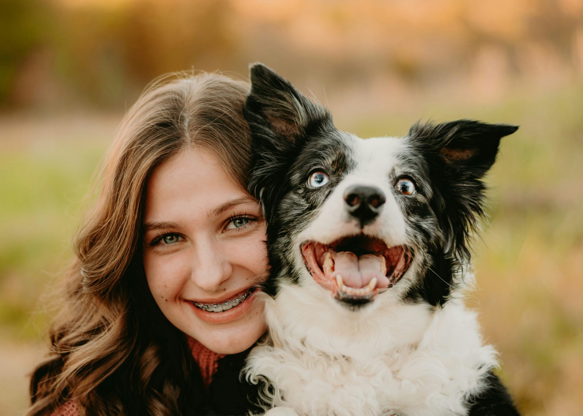 une femme enlace un chien dans un champ
