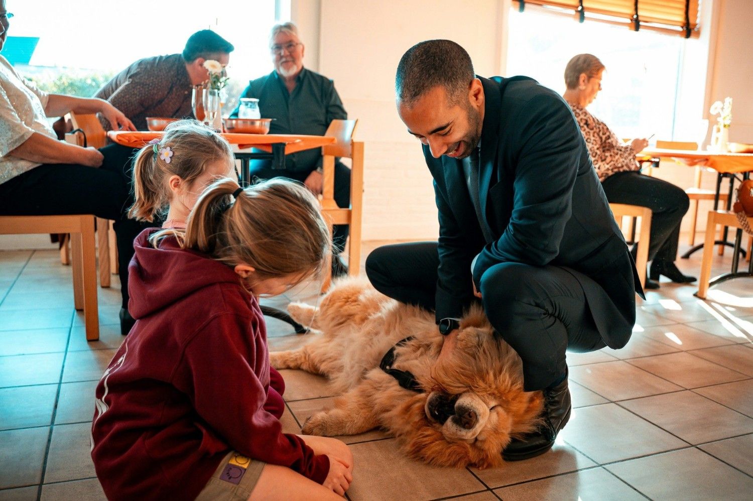 Un homme caresse un chien tout duveteux sous le regard d'un enfant
