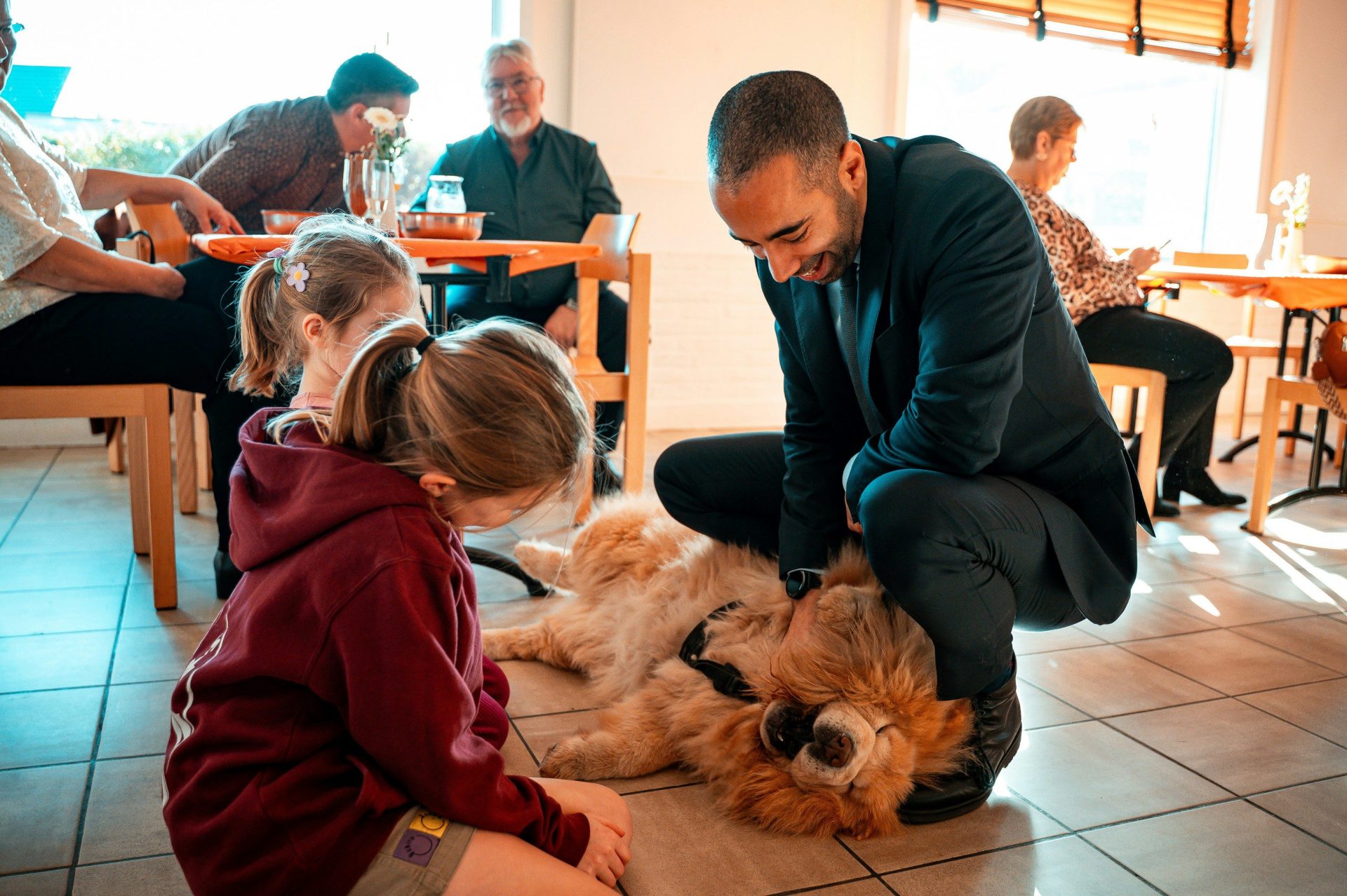 Un homme caresse un chien tout duveteux sous le regard d'un enfant